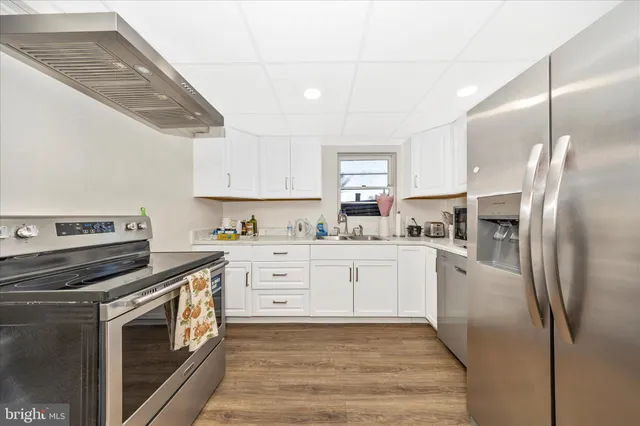 a kitchen with a refrigerator and white cabinets
