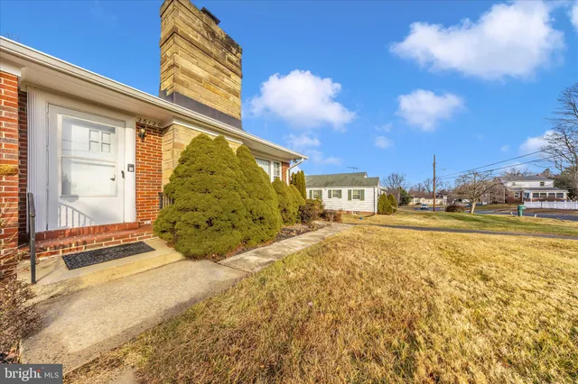 a front view of house with yard and ocean