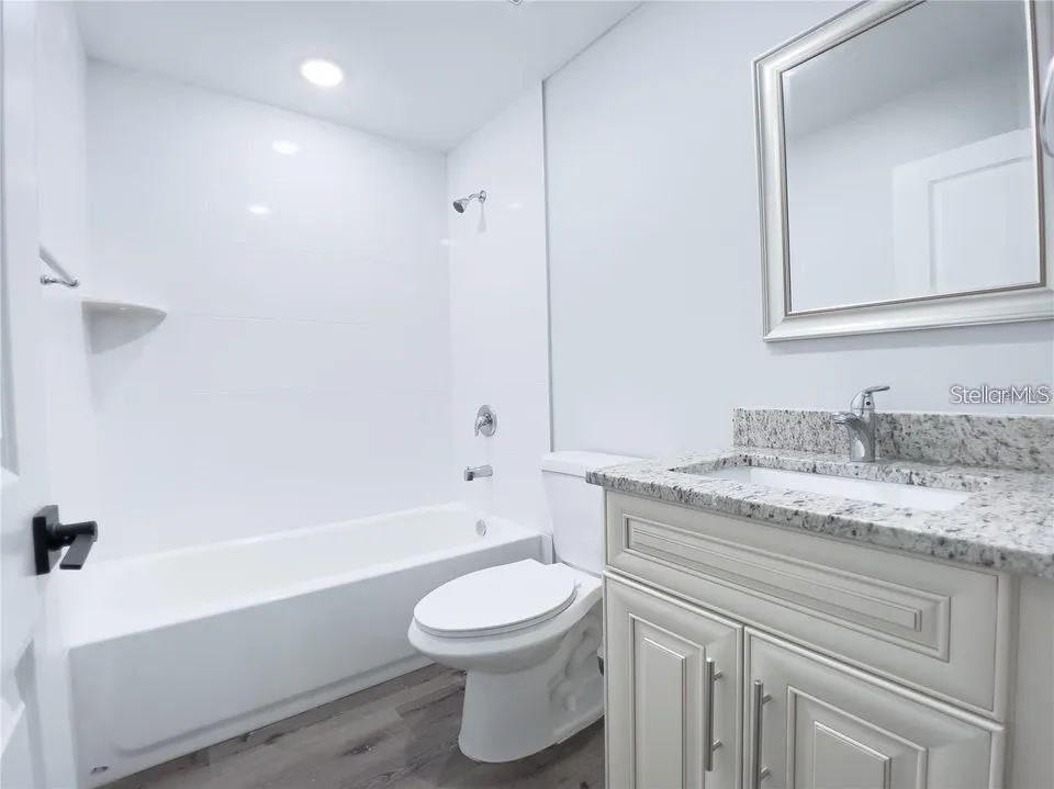 66 Walnut Place Ocala, FL 34480 - Photo 6 of 8 a bathroom with a granite countertop sink toilet a mirror and bathtub