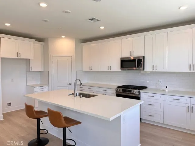 a kitchen with a sink a stove a microwave and cabinets