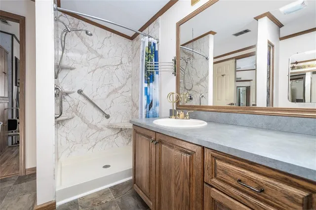 a bathroom with a granite countertop sink and shower