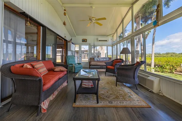 a living room with furniture a rug and a floor to ceiling window