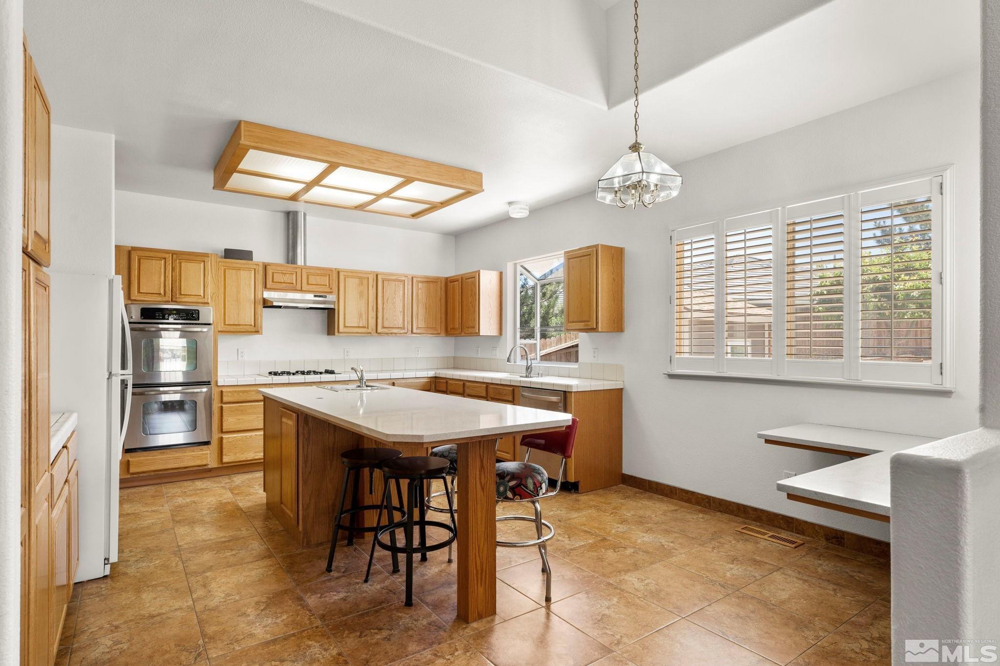 50 Deer Valley Court Reno, NV 89511 - Photo 14 of 39 a kitchen with stainless steel appliances granite countertop a sink a stove and a refrigerator
