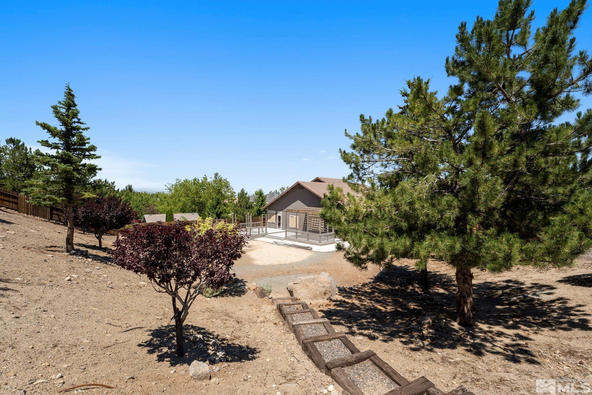50 Deer Valley Court Reno, NV 89511 - Photo 34 of 39 a view of a dry yard with wooden fence and some trees