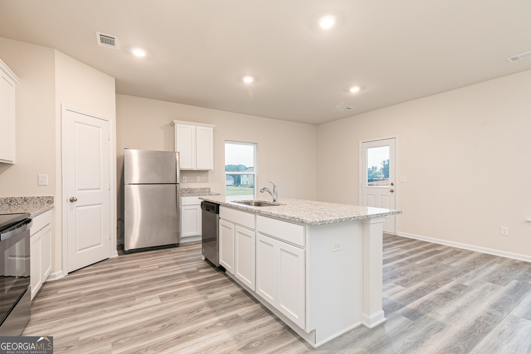 284 Limestone Circle Conyers, GA 30013 - Photo 9 of 25 a kitchen with white cabinets and stainless steel appliances