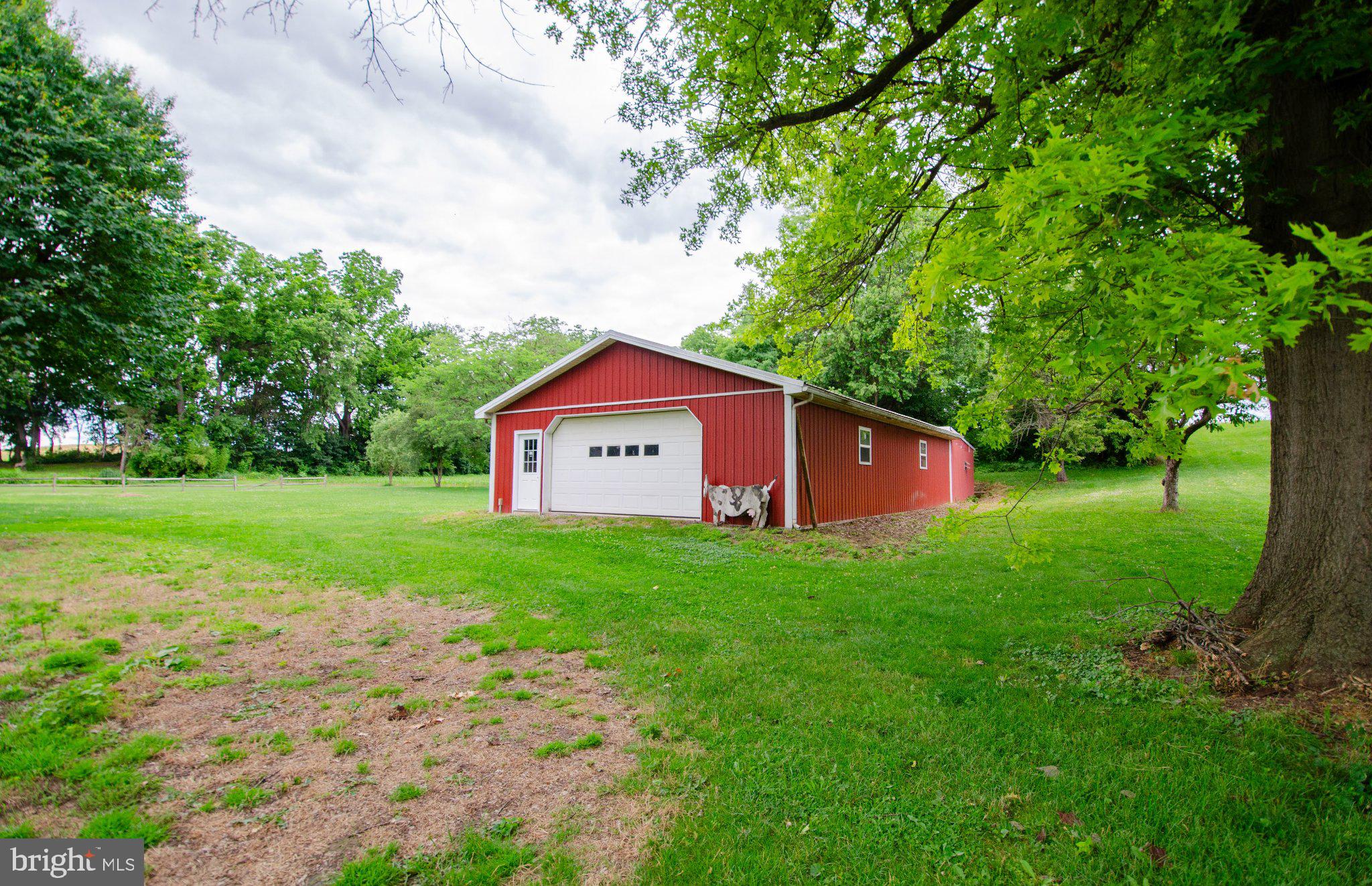 2615 Walnut Bottom Road Carlisle, PA 17015 - Photo 35 of 38 Charming red barn amidst lush greenery.