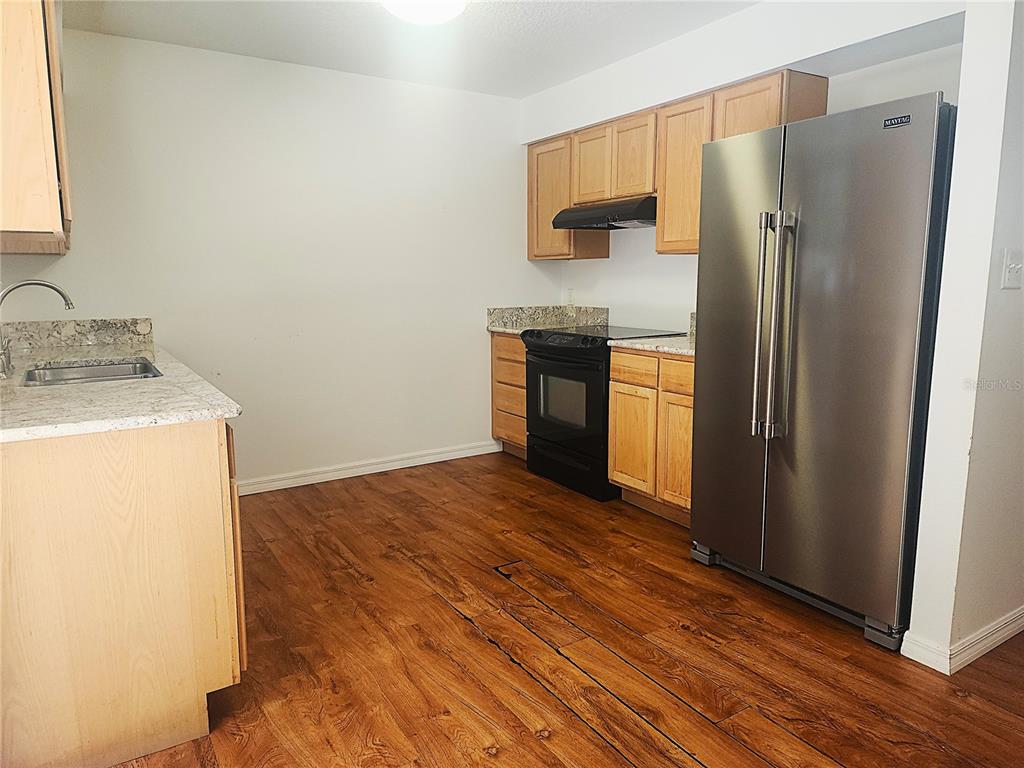63 Estrella Road DeBary, FL 32713 - Photo 12 of 50 a kitchen with granite countertop a refrigerator and a sink