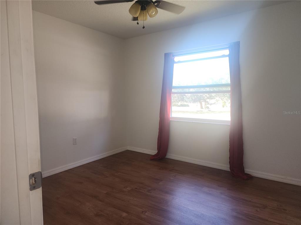 63 Estrella Road DeBary, FL 32713 - Photo 23 of 50 an empty room with wooden floor chandelier fan and windows
