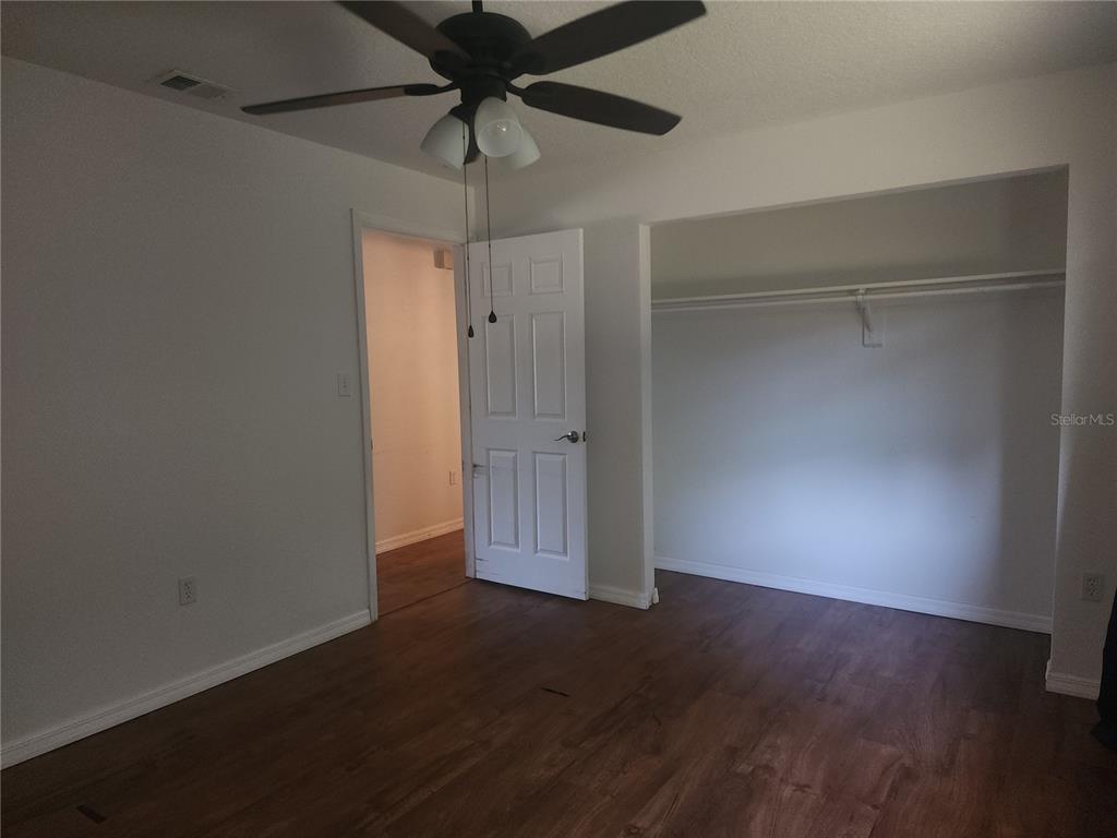 63 Estrella Road DeBary, FL 32713 - Photo 27 of 52 an empty room with wooden floor closet and fan