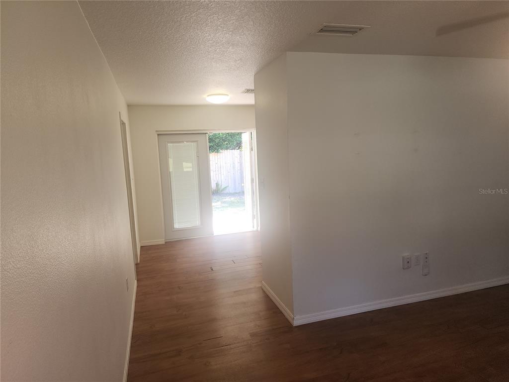 63 Estrella Road DeBary, FL 32713 - Photo 9 of 50 an empty room with wooden floor and windows with curtains