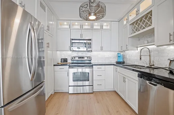 a kitchen with stainless steel appliances a refrigerator sink and cabinets