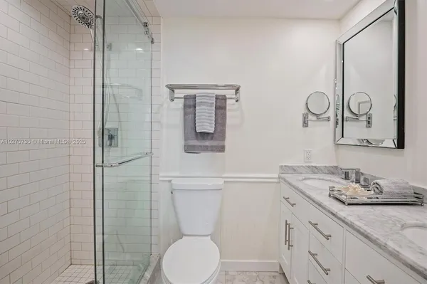 a bathroom with a granite countertop toilet sink and mirror