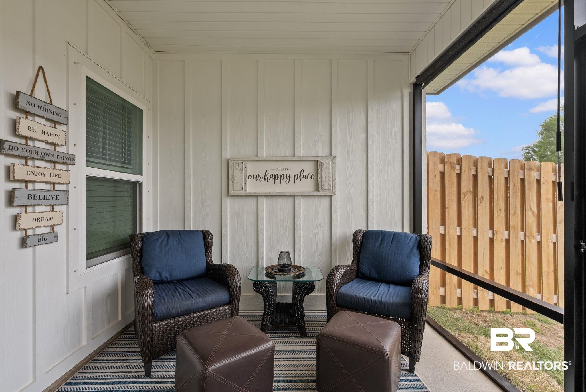 9899 Willet Way Foley, AL 36535 - Photo 28 of 37 Screened porch featuring board and batten wall paneling, a concrete floor, and a window with horizontal blinds