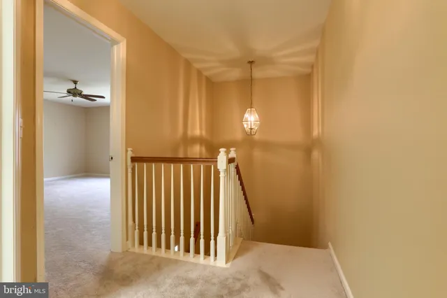 a view of a hallway with wooden floor and a bathroom