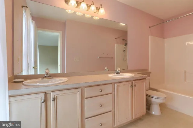 a bathroom with a granite countertop sink a toilet and a mirror