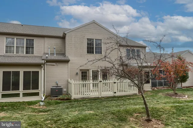 a view of a house with a yard and a large tree