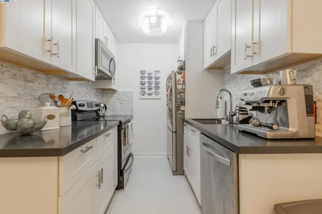 a kitchen with stainless steel appliances granite countertop a sink stove and cabinets