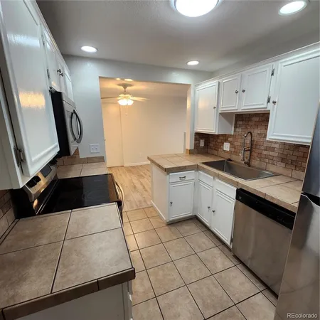 a kitchen with a stove cabinets and microwave
