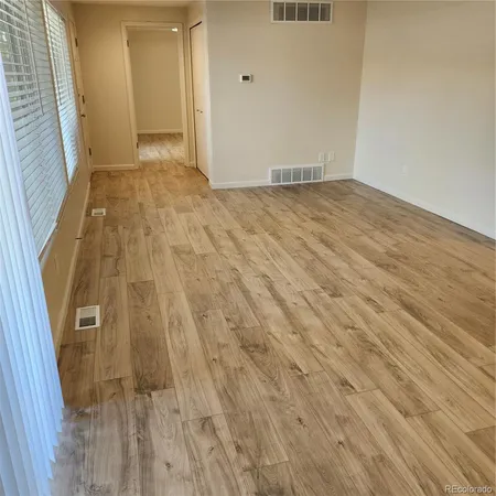 a view of empty room with wooden floor