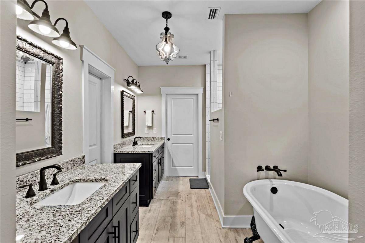 7400 Tidwell Road Pace, FL 32571 - Photo 12 of 36 a bathroom with a granite countertop tub double vanity sink and a mirror