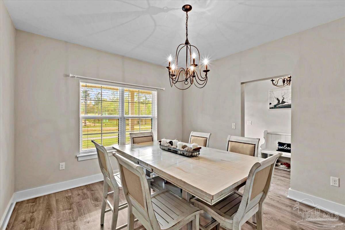 7400 Tidwell Road Pace, FL 32571 - Photo 20 of 36 a view of a dining room with furniture a rug and wooden floor