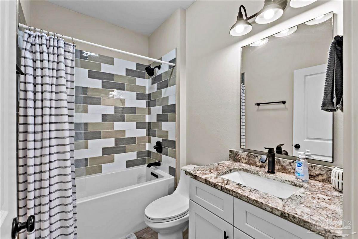 7400 Tidwell Road Pace, FL 32571 - Photo 29 of 36 a bathroom with a granite countertop bathtub sink vanity mirror and toilet