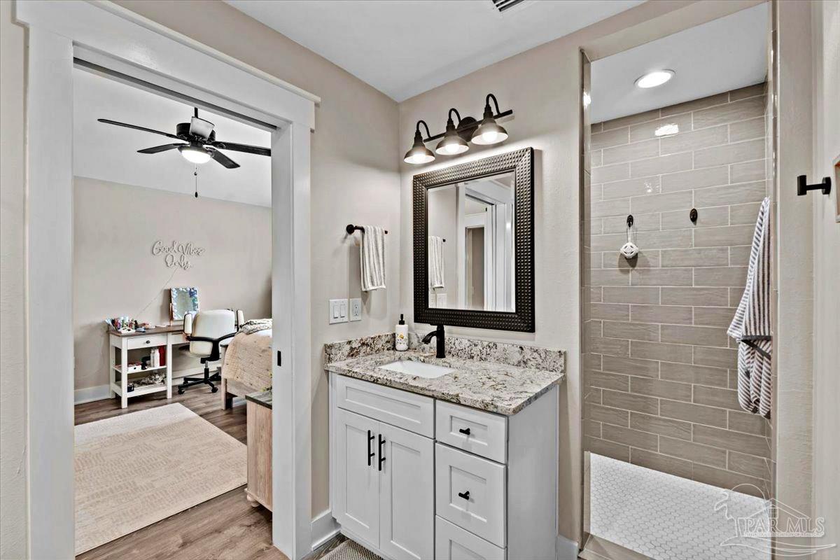 7400 Tidwell Road Pace, FL 32571 - Photo 30 of 36 a bathroom with a granite countertop sink a mirror and shower