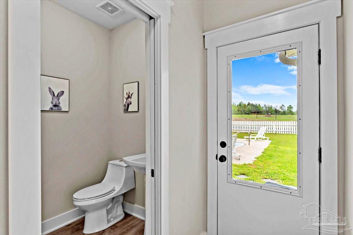 7400 Tidwell Road Pace, FL 32571 - Photo 31 of 36 a bathroom with a toilet and a shower curtain