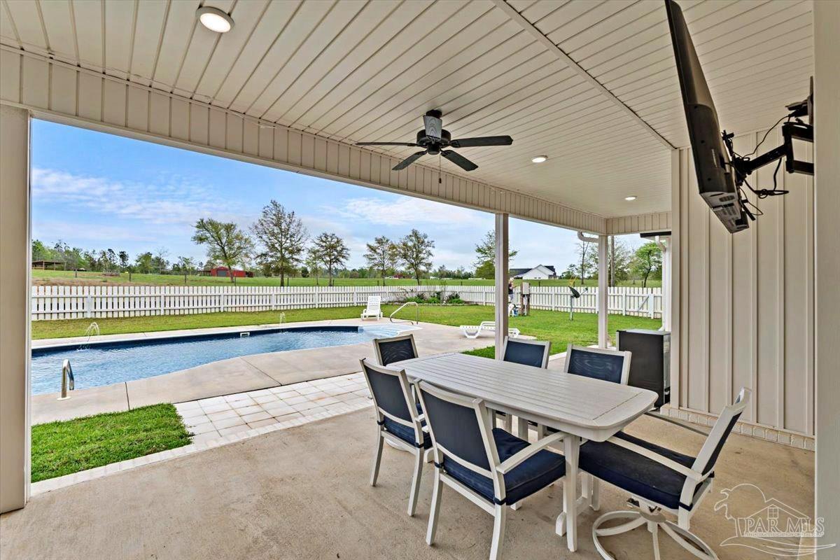 7400 Tidwell Road Pace, FL 32571 - Photo 32 of 36 a view of a patio with a table chairs and a backyard