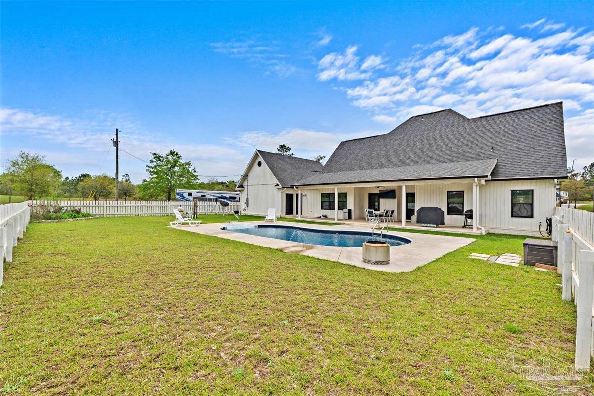 7400 Tidwell Road Pace, FL 32571 - Photo 34 of 36 a view of a house with swimming pool and a yard