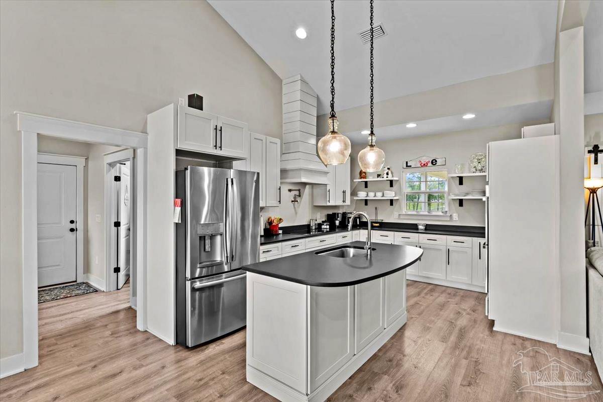 7400 Tidwell Road Pace, FL 32571 - Photo 4 of 36 a kitchen with refrigerator a sink and chairs