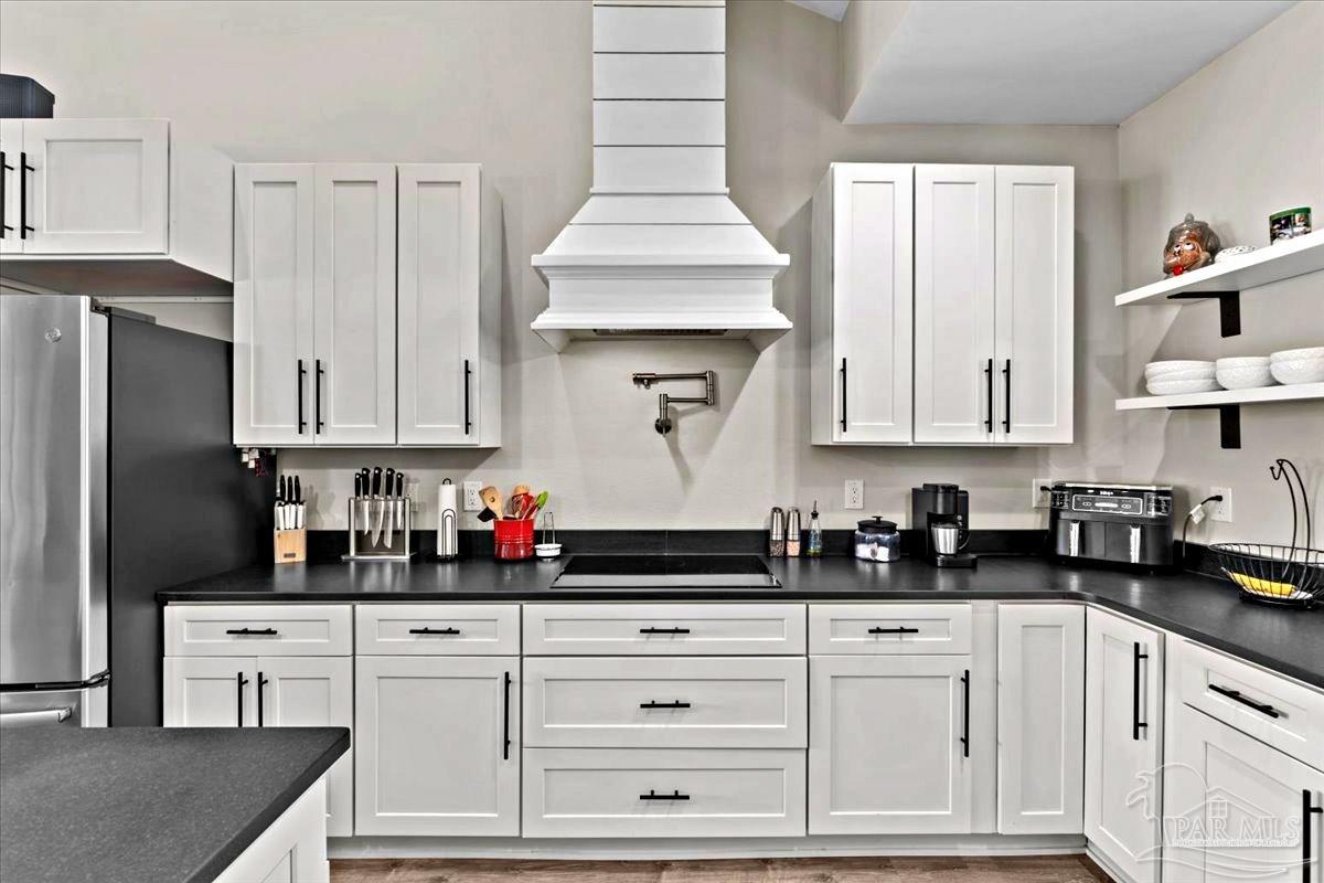 7400 Tidwell Road Pace, FL 32571 - Photo 8 of 36 a kitchen with white cabinets and window