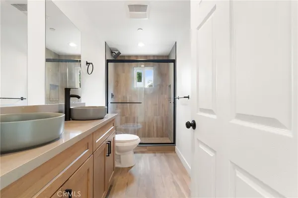 a bathroom with a granite countertop toilet sink and mirror