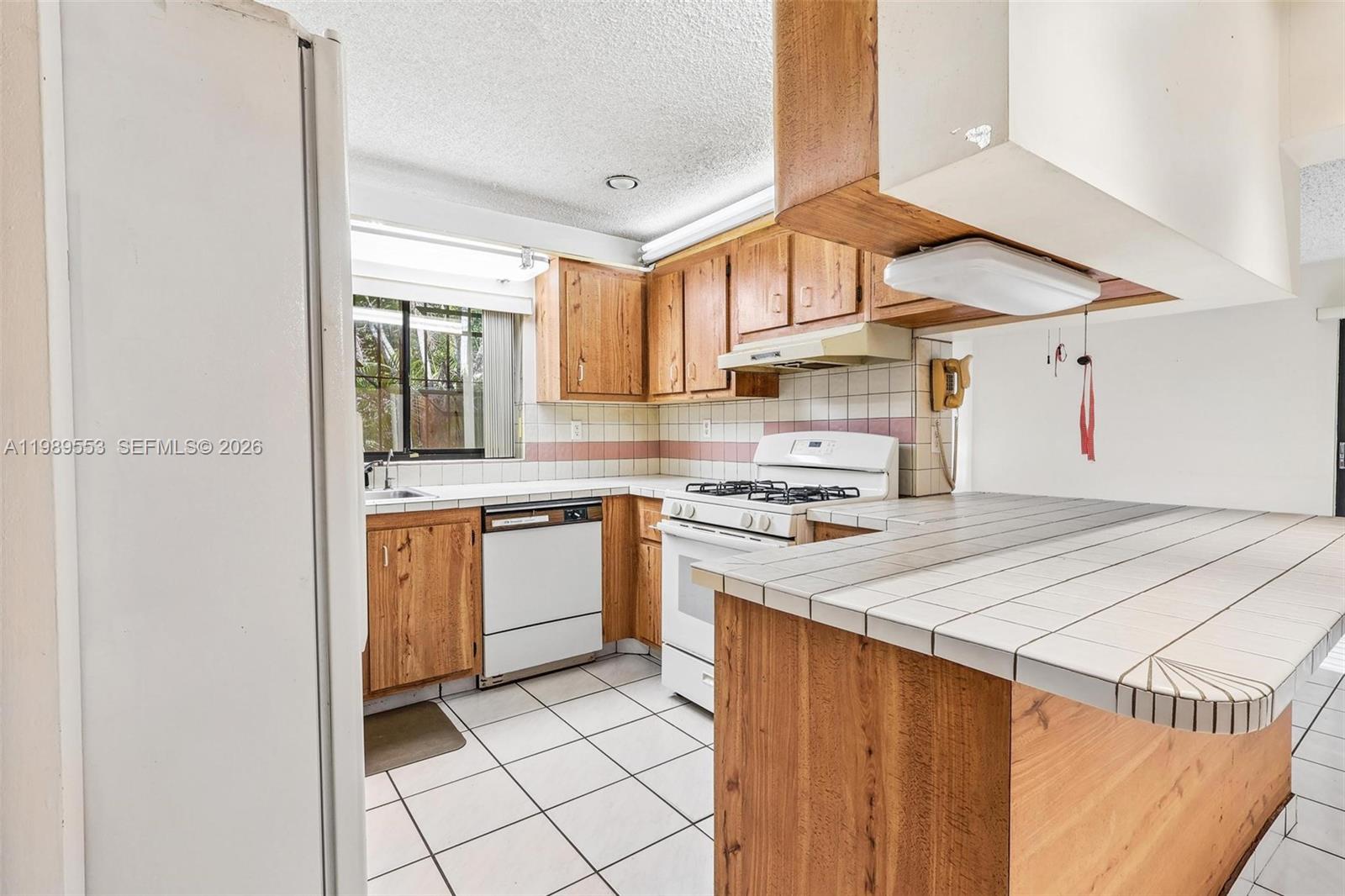 4210 Southwest 134th Avenue Miami, FL 33175 - Photo 11 of 32 a kitchen with a stove a sink and a refrigerator