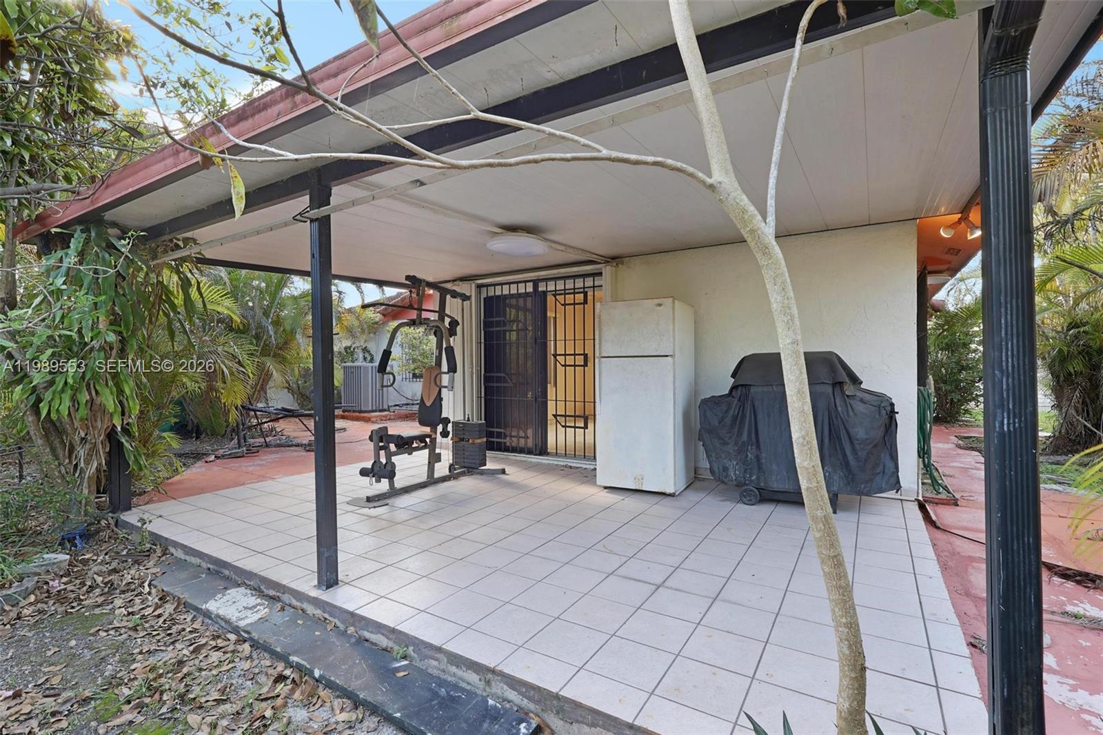 4210 Southwest 134th Avenue Miami, FL 33175 - Photo 21 of 32 a view of a patio with table and chairs under an umbrella