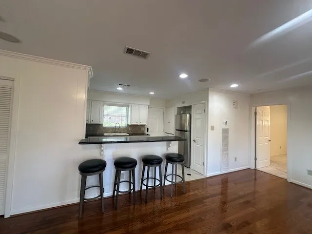 a kitchen with stainless steel appliances granite countertop a stove top oven a sink refrigerator and cabinets