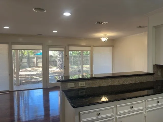 a kitchen with granite countertop a stove and a large window