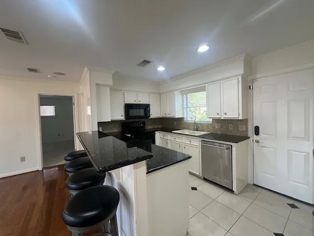 a kitchen with granite countertop white cabinets a sink and white appliances