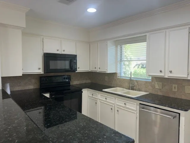 a kitchen with a sink stove and cabinets