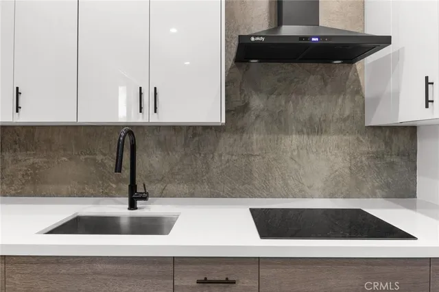 a kitchen with stainless steel appliances granite countertop a refrigerator a sink and white cabinets