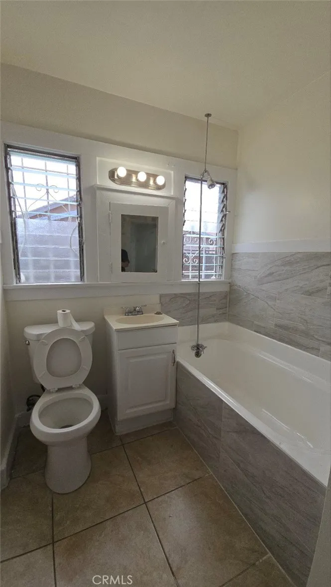 456 West 59th Place Los Angeles, CA 90003 - Photo 19 of 21 a bathroom with a sink toilet a mirror and bathtub