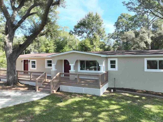 a front view of a house with a garden and trees