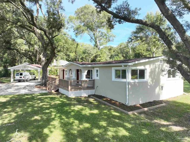 a front view of house with yard and trees in the background
