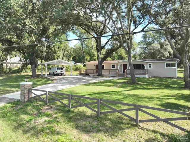 a view of a house with backyard and sitting area