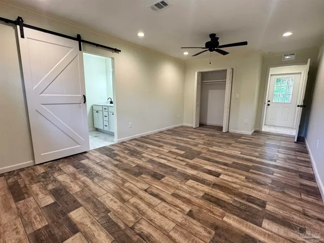 a view of a livingroom with wooden floor and a ceiling fan
