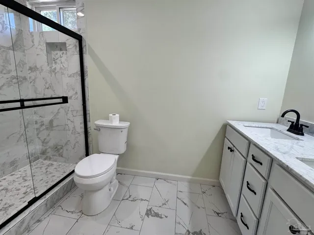 a bathroom with a granite countertop sink toilet and a shower