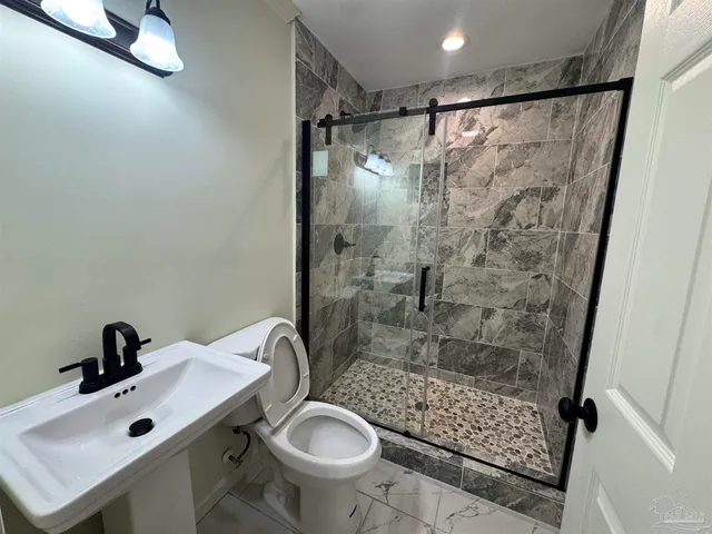 a bathroom with a sink toilet a mirror and shower