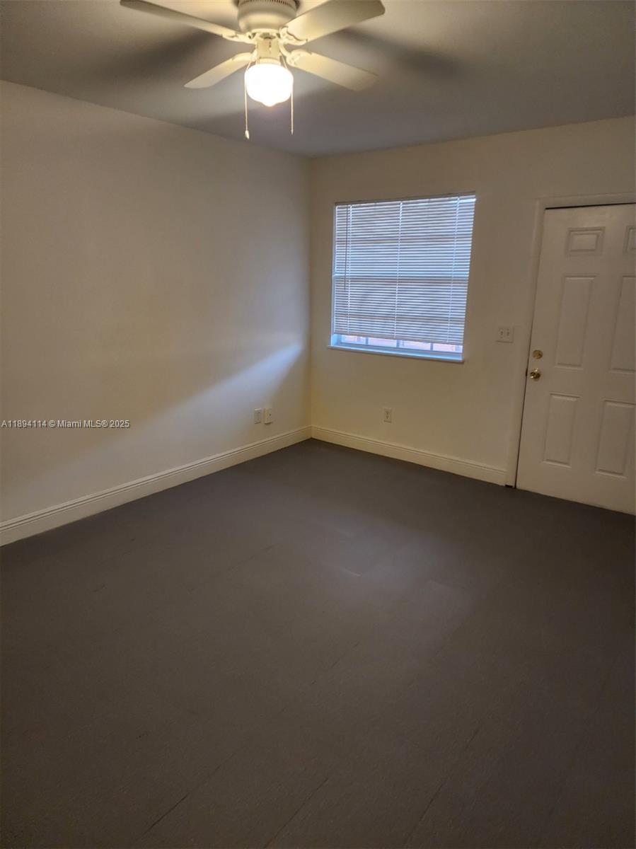 14240 Northwest 22nd Avenue, Unit 3 Opa-Locka, FL 33054 - Photo 20 of 49 an empty room with a ceiling fan and window