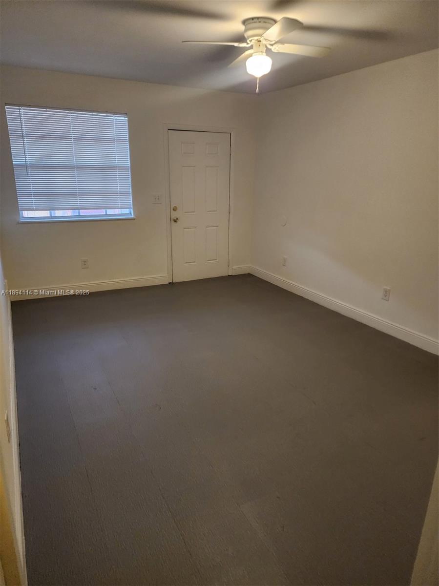 14240 Northwest 22nd Avenue, Unit 3 Opa-Locka, FL 33054 - Photo 24 of 49 an empty room with a ceiling fan and window