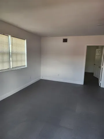 an empty room with a ceiling fan and a window